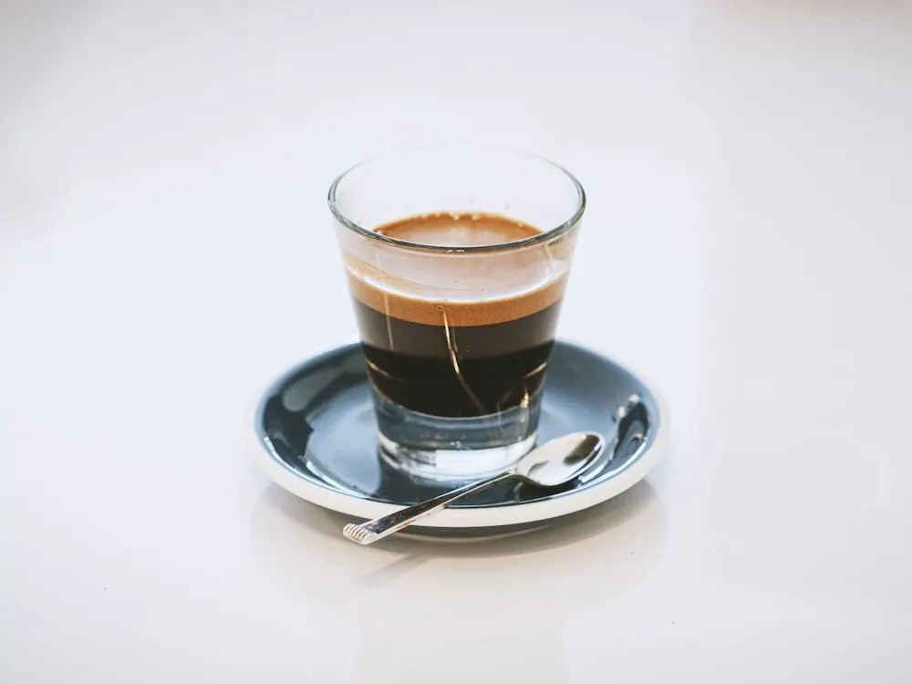 Beyaz zeminde cam bardakta espresso